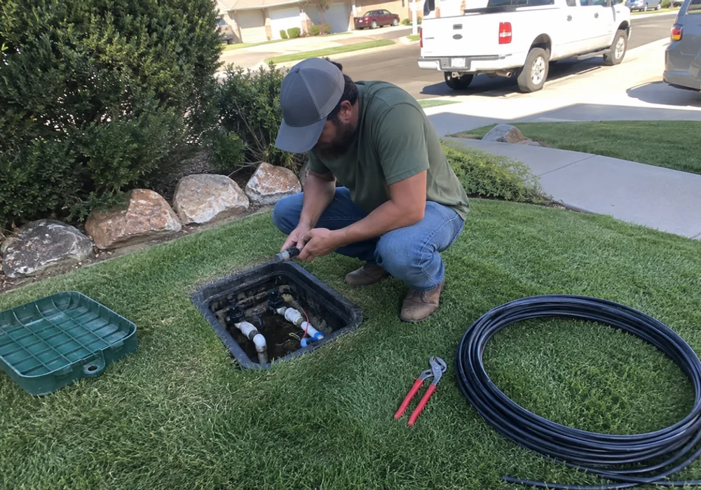A YLC landscaper checking irrigation coverage on a residential Utah lawn